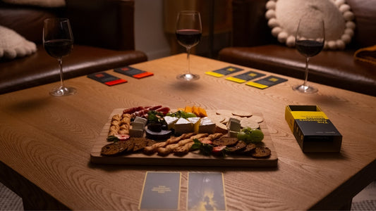 The Collector's Stories card game night with wine and a charcuterie board on a table