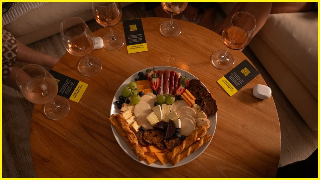 A group of friends gathered for a cozy night in, sharing wine and charcuterie with The Collectors Stories game cards on the table.